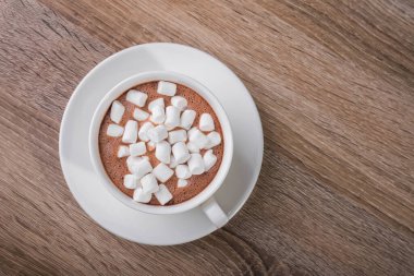 Beyaz kahve fincanı ve ahşap bir masada tatlı şekerlemesi. en üstteki görünüm