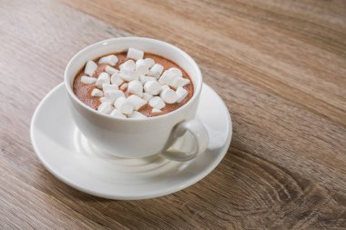 Beyaz kahve fincanı ve ahşap bir masada şekerleme.