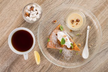Nane yapraklı lezzetli pasta ve dondurma topları, ahşap bir masada beyaz çay fincanı. Tatlı geçmişi güzelmiş. Üst görünüm.