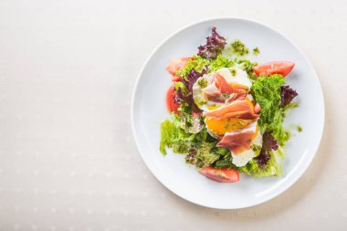 Haşlanmış yumurta, et ve beyaz tabakta domates salatası. sağlıklı yemek arkaplanı.