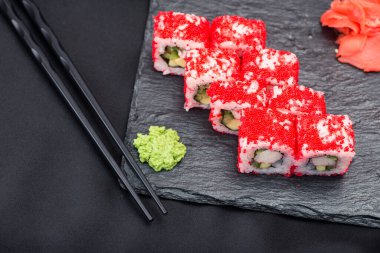 Siyah çubuklu siyah tahtada taze suşi. Japon gıda arka planı.