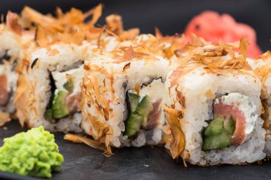 Siyah çubuklu siyah tahtada taze suşi. Japon gıda arka planı.