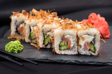 Siyah çubuklu siyah tahtada taze suşi. Japon gıda arka planı.