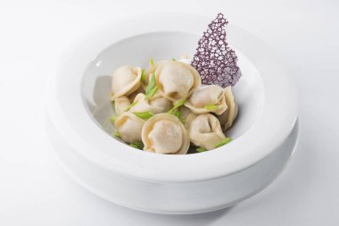 Beyaz tabakta soğanlı lezzetli hamur tatlısı.