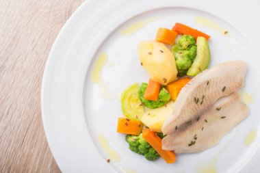 Beyaz tabakta sebzeli haşlanmış balık. Diyet sağlıklı yemek. en üstteki görünüm