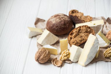 Brie peynirli ceviz, ahşap masada ekmek. Süt ürünleri arka planı