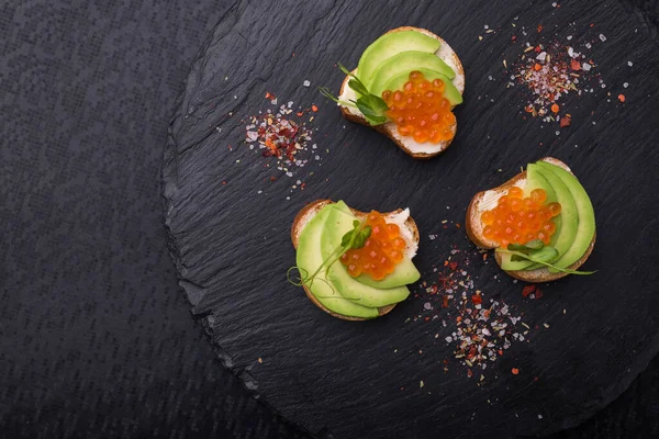 Sabrosa Bruschetta Con Aguacate Caviar Una Pizarra Negra Aperitivo Snack —  Fotos de Stock