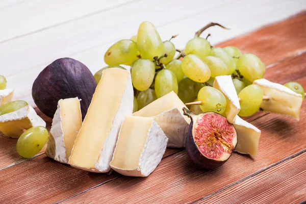 Pezzi Camembert Brie Formaggio Con Uva Fico Noci Tavolo Legno — Foto Stock