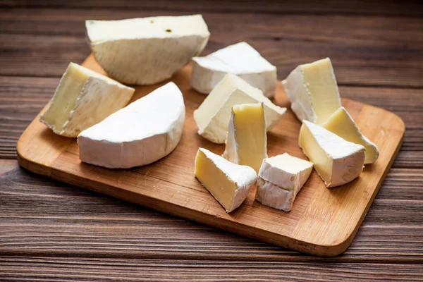 木製の板においしいチーズのキャンベルセット 牛乳製品の背景 — ストック写真