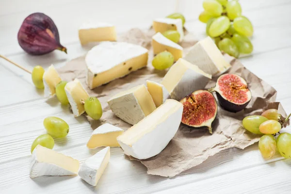 Pezzetti Brie Camembert Tavolo Legno Bianco Con Uva Frutto Fico — Foto Stock