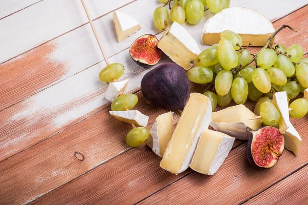 Pezzi Camembert Brie Formaggio Con Uva Fico Noci Tavolo Legno — Foto Stock