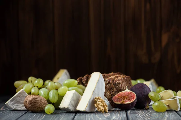 Pezzi Camembert Brie Formaggio Con Uva Fico Noci Tavolo Legno — Foto Stock