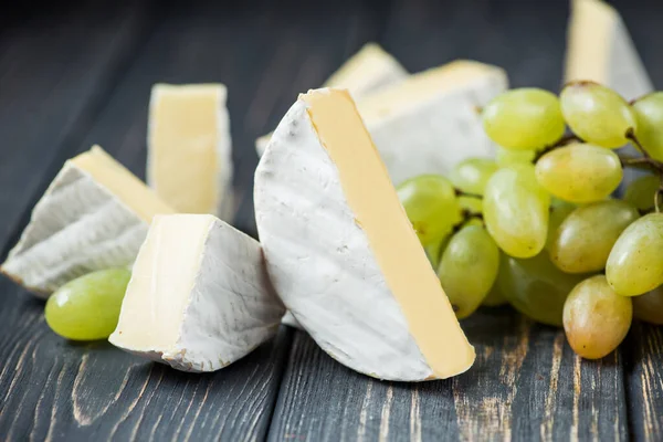 Pezzi Bianchi Camembert Brie Con Uva Verde Tavolo Legno — Foto Stock