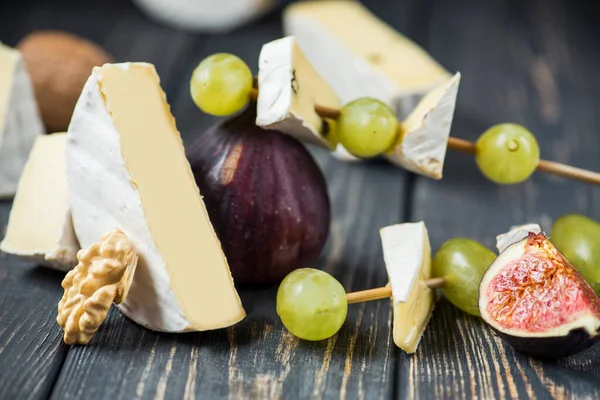 Pezzi Camembert Brie Formaggio Con Uva Fico Noci Tavolo Legno — Foto Stock