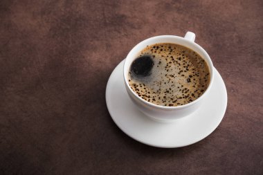 Beyaz aromalı kahve fincanı, klasik beton masa arkaplanı, üst manzara, espresso içeceği.