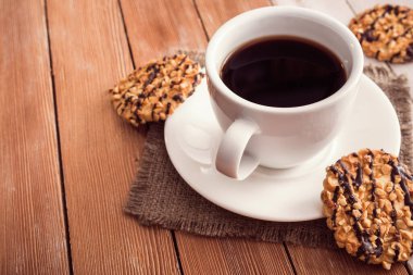 Tahta bir masada çikolatalı kurabiyeli kahve fincanı