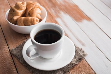Aromalı kahve ve ahşap bir masada tatlı kruvasan, Avrupa kahvaltısı