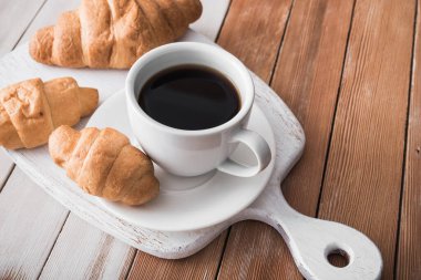 Aromalı kahve ve ahşap bir masada tatlı kruvasan, Avrupa kahvaltısı
