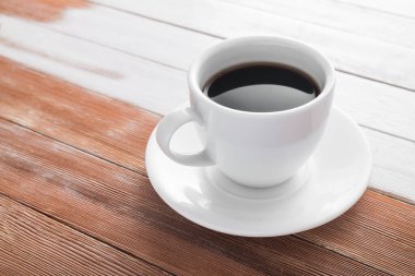 Ahşap bir masada bir fincan aroma.