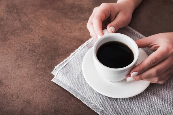 Vrouw Houdt Een Wit Kopje Koffie Bruine Stenen Tafel — Stockfoto