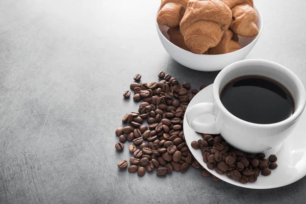 Weiße Kaffeetasse Mit Süßem Croissant Und Gerösteten Bohnen Auf Betongrund — Stockfoto