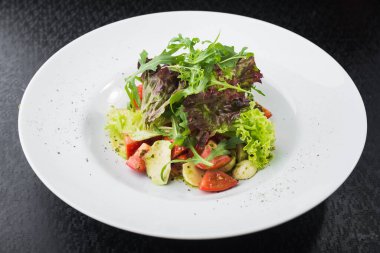 Domatesli vejetaryen salatası ve beyaz tabakta mozzarella peyniri.