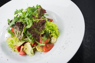 Domatesli vejetaryen salatası ve beyaz tabakta mozzarella peyniri.