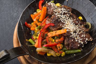 Susamlı ızgara et ve kızartma tavasında ızgara sebze. Restoran servis yemekleri