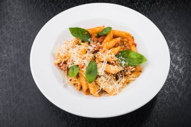 Beyaz tabakta fesleğenli makarna. Restoran yemekleri