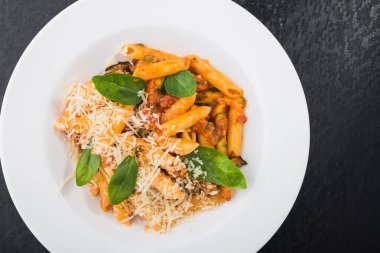 Beyaz tabakta fesleğenli makarna. Lokanta yemeği. en üstteki görünüm