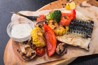 Izgara sebzeler ve kağıt üzerinde balık uskumrusu. Izgaradan besleyici yiyecekler.