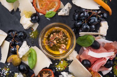 Lezzetli peynirli sos, prosciutto ve siyah tahtada üzümler. Lokanta Foo