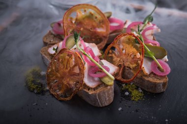 Soğan ve yemek ile atıştırmalık bruschetta, domates ve siyah tahta, restoran dumanlı servis