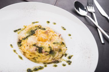 Taze spagetti makarna carbonara ile yumurta ve peynirli parmesan beyaz tabak