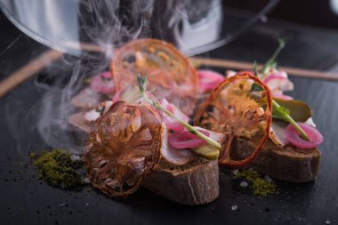 Soğan ve yemek ile atıştırmalık bruschetta, domates ve siyah tahta, restoran dumanlı servis