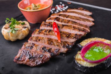 Siyah tahtada kırmızı biberli ızgara biftek. Restoranda et servisi