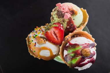 Siyah arka planda waffle 'lı tatlı dondurma topları.