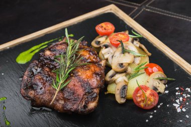Biberiyeli biftek ve tahtanın üzerinde patates ve mantar tabağı.