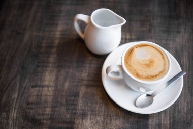 Kafedeki masada bir fincan kahve. Sabah arkaplanından beri taze içki