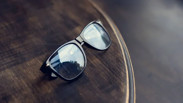 Černé Brýle Odrazem Dřevěném Stole — Stock fotografie