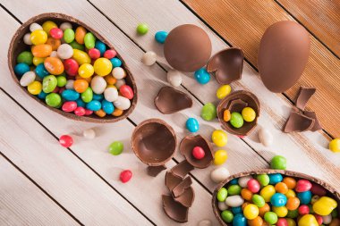 Paskalya tatlısı lezzetli çikolatalı yumurta ve ahşap masa üzerinde renkli şeker sürahisi.