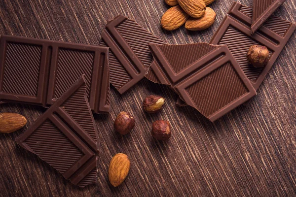 Tumpukan Coklat Batangan Dengan Kacang Atas Meja Kayu — Stok Foto