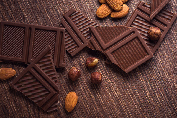 Pile of chocolate bars with nuts on a wooden table