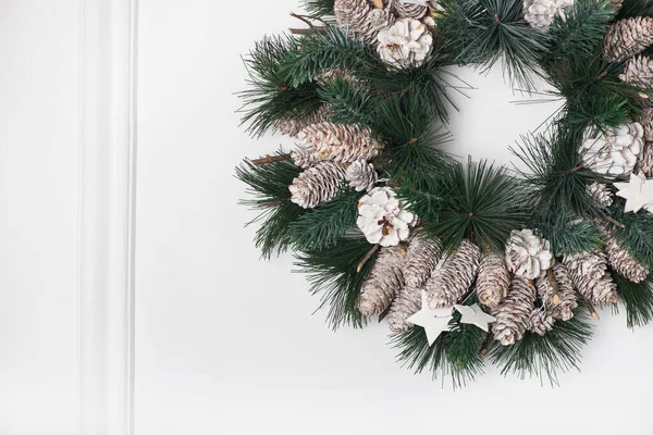 Weihnachtskranz Mit Tannenzapfen Und Holzsternen Auf Einer Weißen Gipswand — Stockfoto