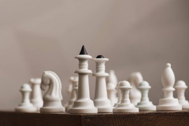 Tahta bir yüzeyde beyaz bir satranç takımı.