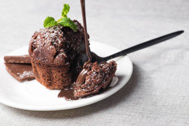 Beyaz tabakta erimiş çikolatalı tatlı kek.