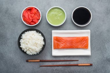 Evde suşi, somon balığı, wasabi, zencefil, çubuk ve pilav yapmak için malzemeler.