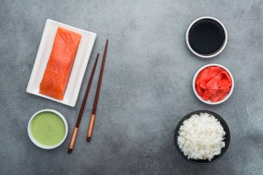 Evde suşi, somon balığı, wasabi, zencefil, çubuk ve pilav yapmak için malzemeler.