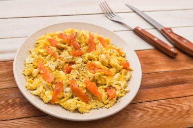 Tahta bir masada somon balığıyla çırpılmış kahvaltı. Kırsal gıda tarzı