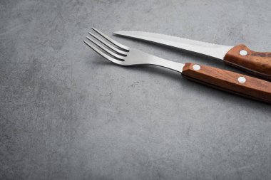 Taş bir masada metal çatal ve bıçak.